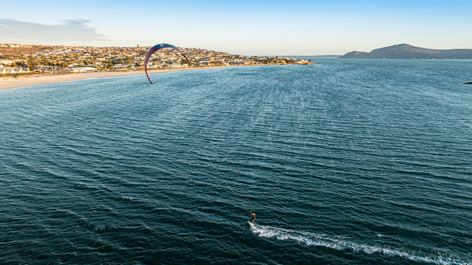 Kitesurfer on Langebaan Lagoon with the town in the background